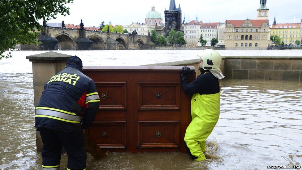 Fireman carry furniture to create a flood barrier in central Prague (2 June 2013)