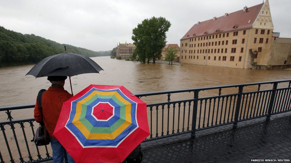 People look out from a bridge over the river Mulde at the flooded embankments of Grimma, near Leipzig June 2, 2013.