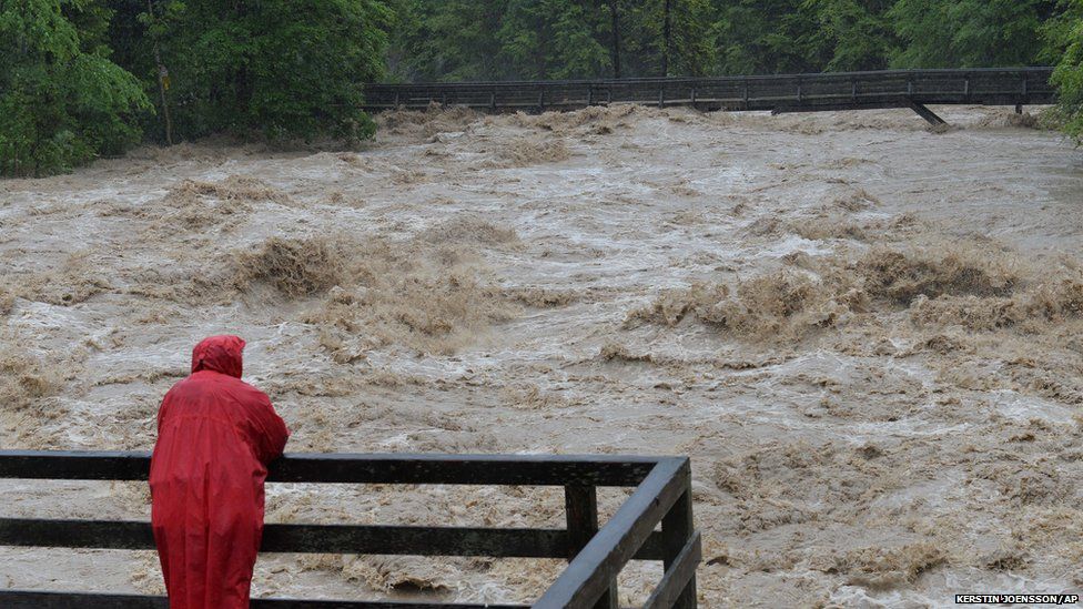 A local resident watches the swollen river Saalach, in Lofer in the Austrian province of Salzburg, Sunday, June. 2, 2013