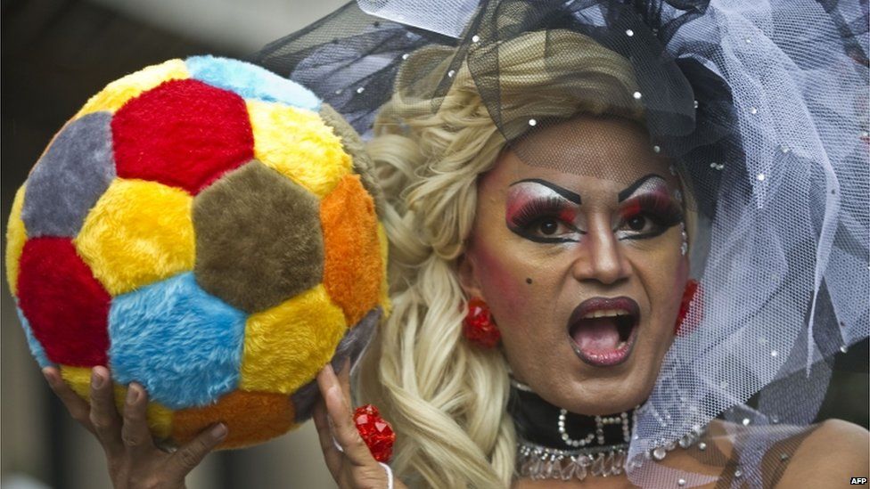 A participant at the Gay Pride march in Sao Paulo holds up a fluffy football.