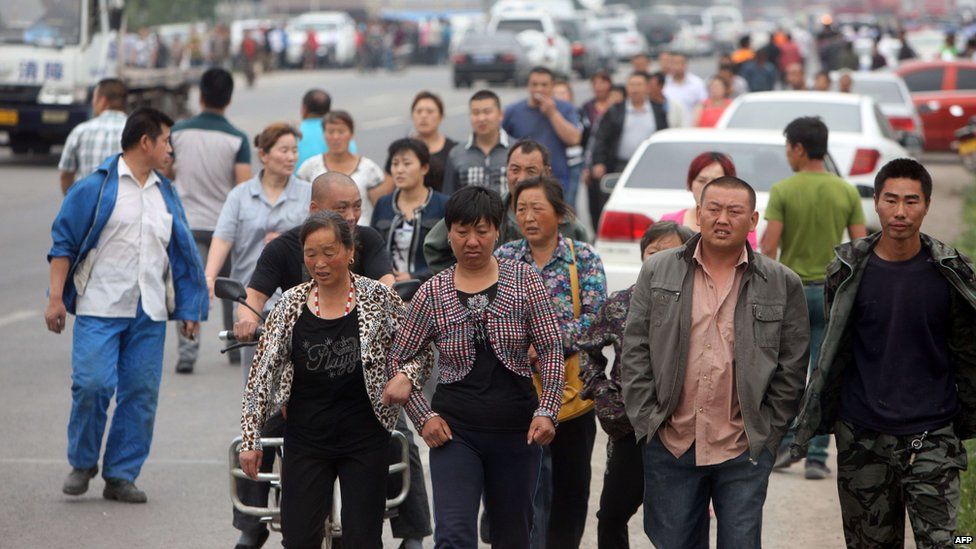 Relatives of victims leave the scene of a blaze from Baoyuan poultry plant at Dehui, in north-east China's Jilin province, 3 June 2013