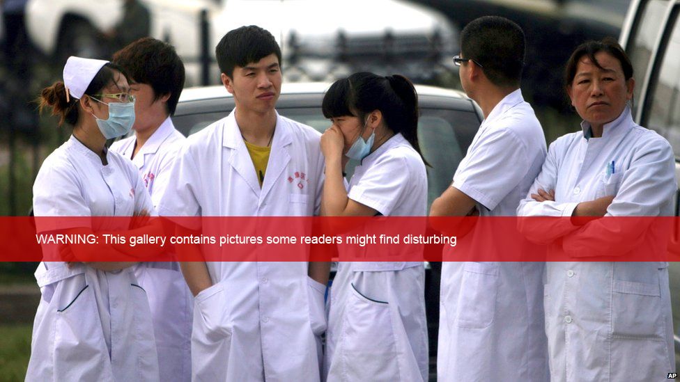 Medical staff wait near a poultry processing plant that was engulfed by a fire in Dehui, north-east China's Jilin province, 3 June 2013