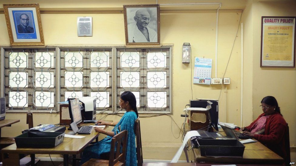 Employees feed in telegram messages onto computers to be sent via telegraph at a telecommunications office in Bangalore