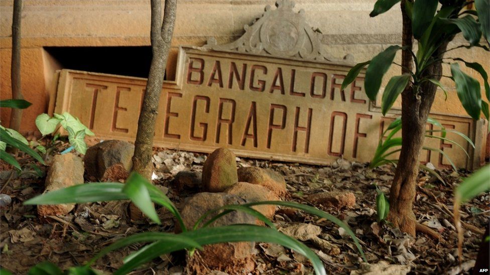 A derelict name board for the Bangalore Telegraph office lies on the ground outside the telecommunications office premises in Bangalore