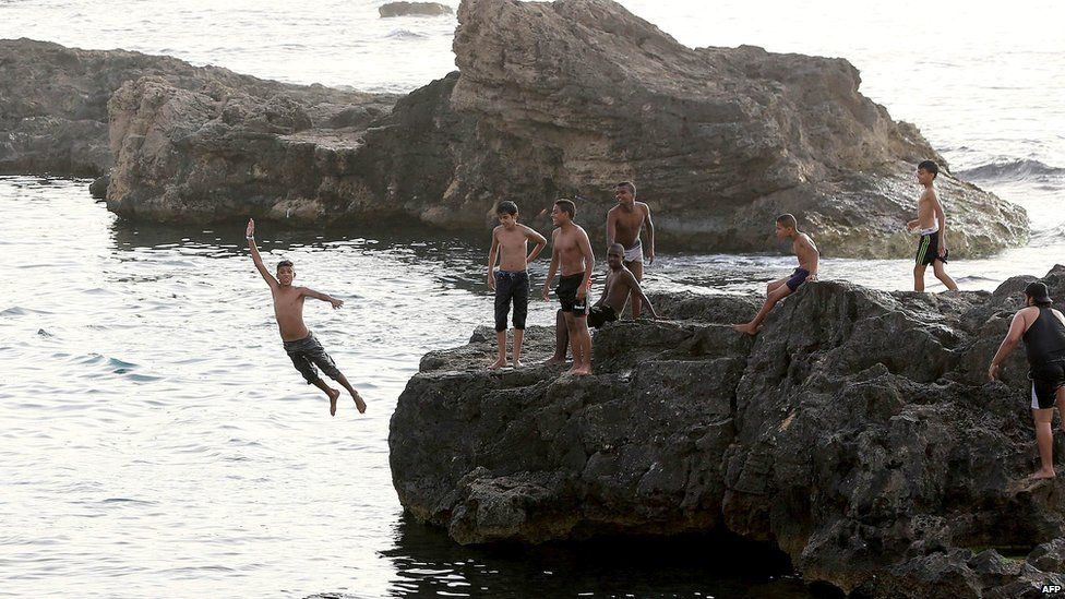Boys playing on rocks at the seaside in Tripoli, Libya - Sunday 9 June 2013