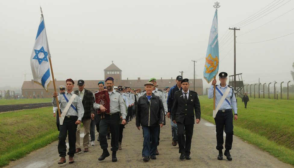 Israeli forces march out Auschwitz, holding aloft the Star of David