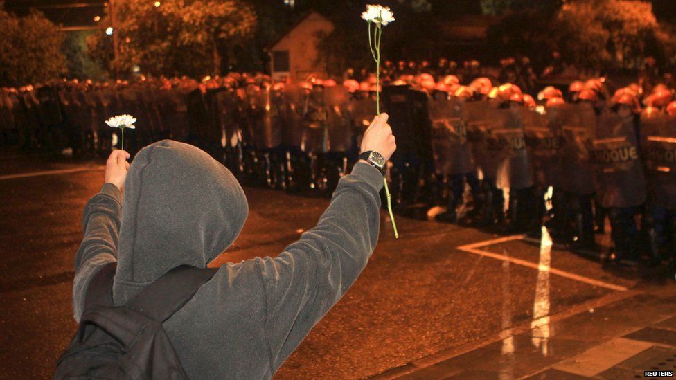 Demonstrator offers flowers to riot police in Porto Alegre, southern Brazil, on 20 June 2013
