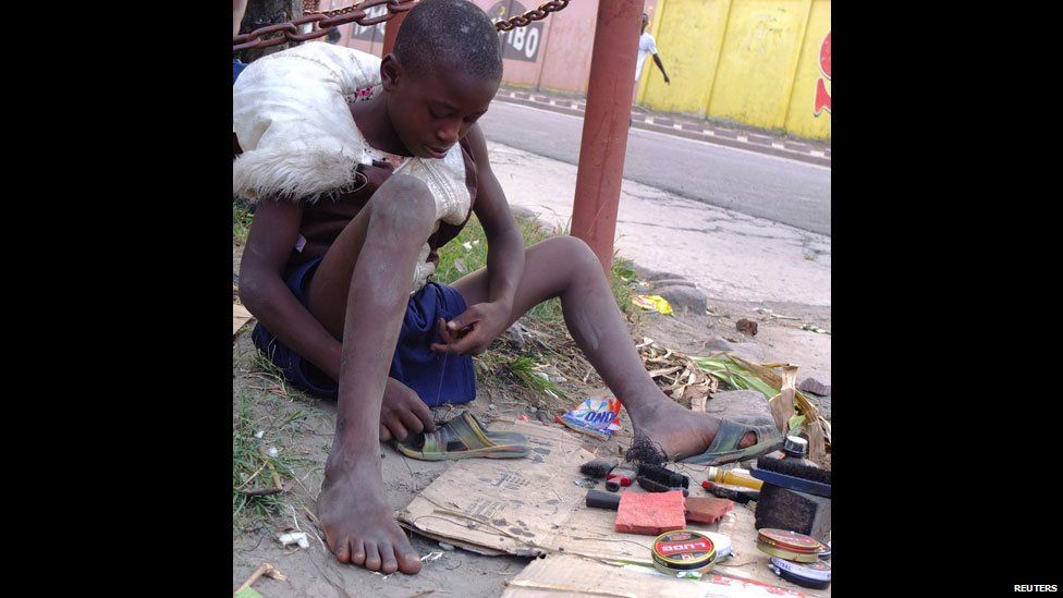 A child repairing a shoe on the side of the road in Kinshasa, DR Congo - Sunday 16 June 2013