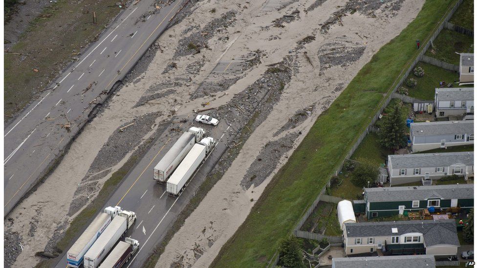 A police car and trucks blocked on a flooded Trans-Canada Highway in Canmore, Alberta, Canada, on 21 June.