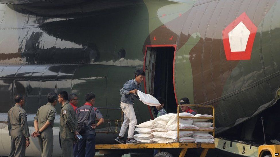 Workers load sacks of salt that will be used for cloud seeding to induce rain in Pekanbaru, Riau province, June 22