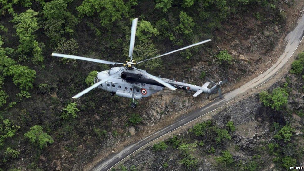 An Indian Air Force helicopter flies over the Gauchar area of Uttarakhand