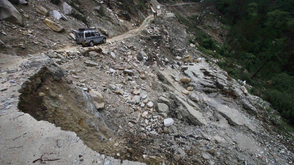 Vehicle moves along a damaged road caused by landslides, in Gaucha, Uttarakhand