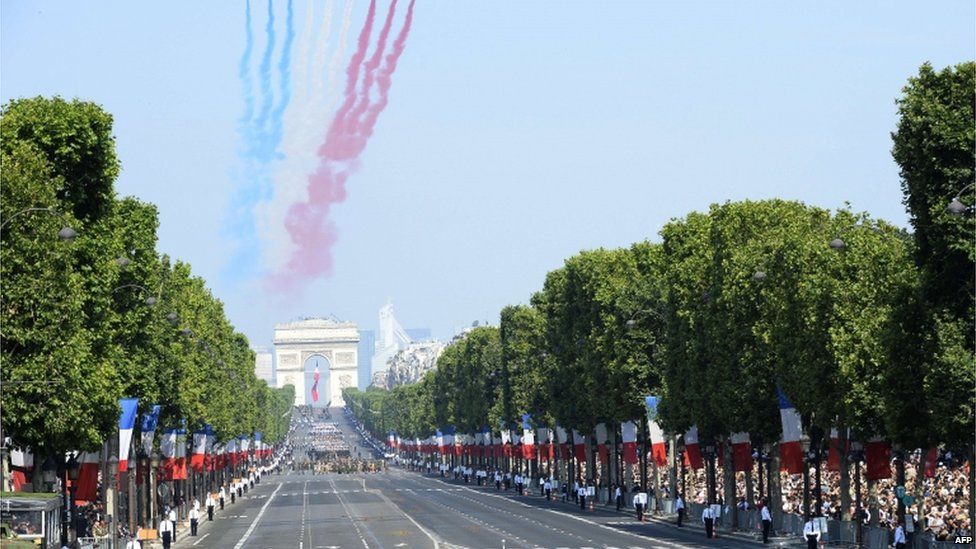 Nine planes from the French Air Force Patrouille de France release trails of red, white and blue smoke, the colours of French national flag as they take part in a fly over during the Bastille Day parade on the Champs-Elysees avenue.