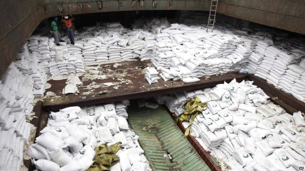 Panamanian workers stand atop sacks of sugar inside a North Korean-flagged ship