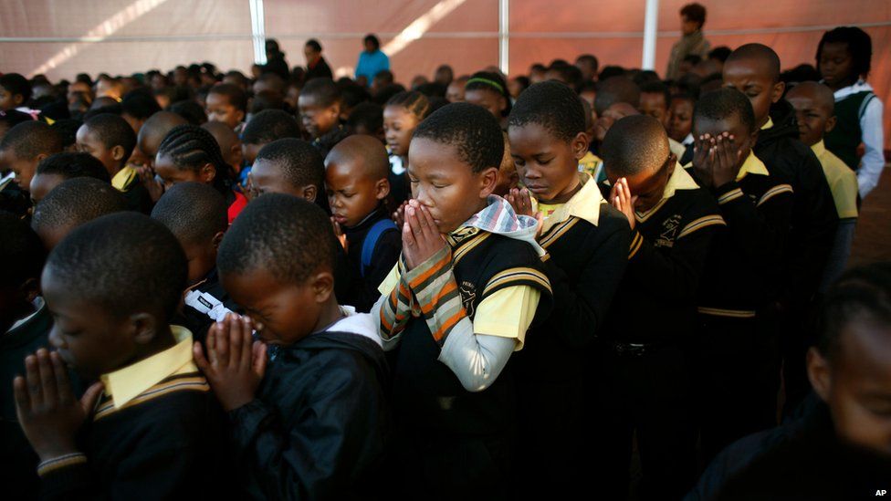 Pupils at the Denver primary school in Johannesburg pray for Nelson Mandela (18 July)