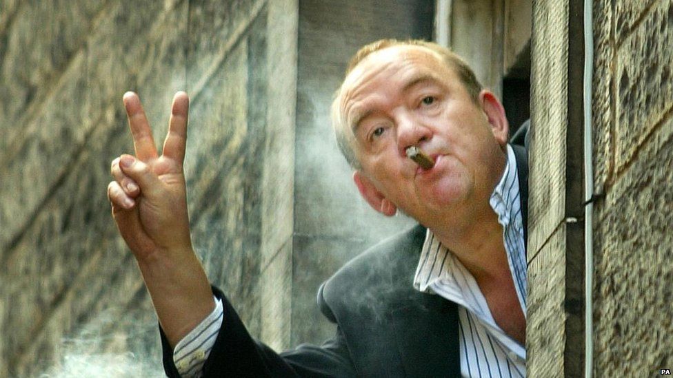 Mel Smith appears smoking a cigar out of a window at the Assembly Halls in Edinburgh
