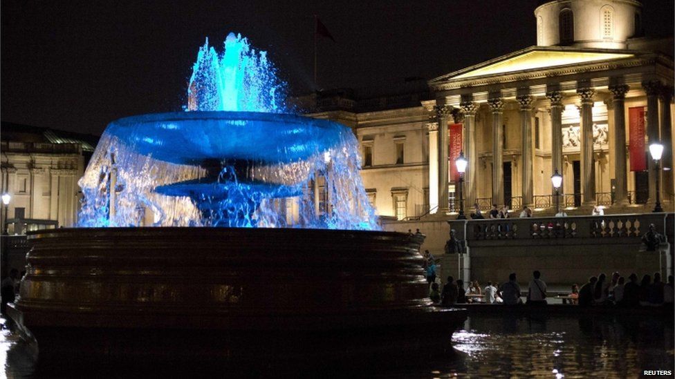 The fountains in Trafalgar Square lit up blue