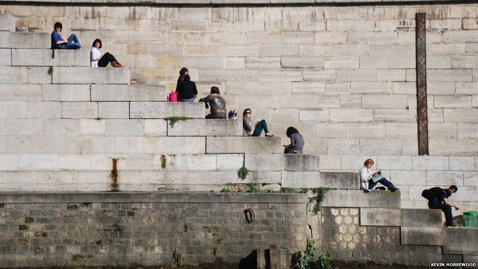 People on steps at the side of the River Seine, Paris