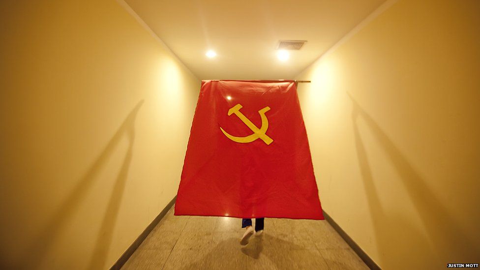 A large communist flag being carried along a corridor by a participant at Vietnam's 11th party congress