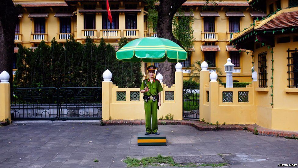 A police officer stands in front of a government building in Hanoi.