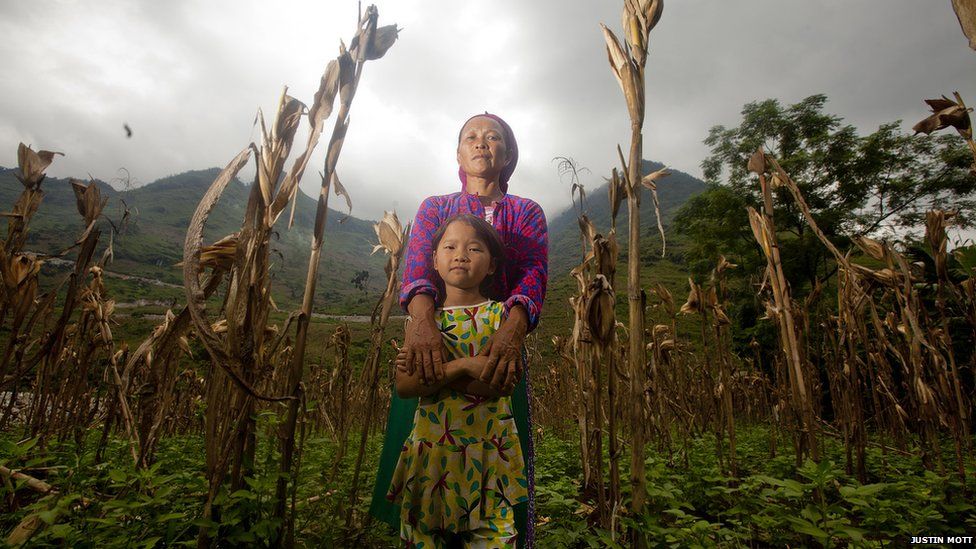 A mother and child stand in a field in northern Vietnam
