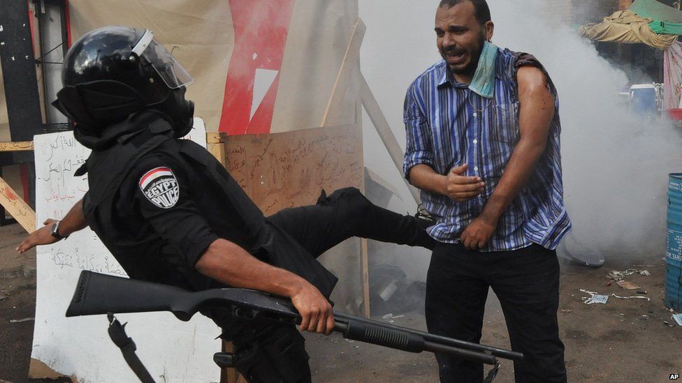 Policeman kicks supporter of ousted President Mohammed Morsi as they clear sit-in camp set up near Cairo University. 14 Aug 2013