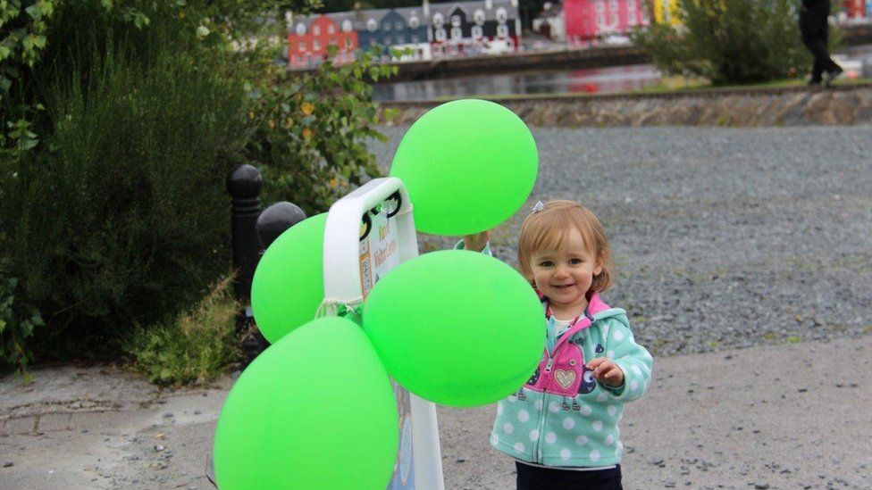 Isla standing by balloons