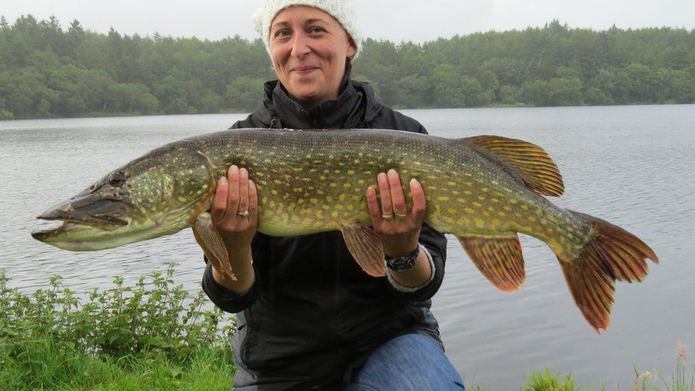 Angela holding a pike fish
