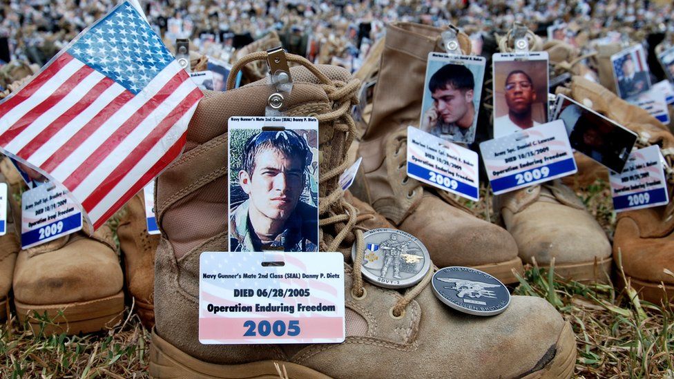 Boots with photos, flags and medals attached to them