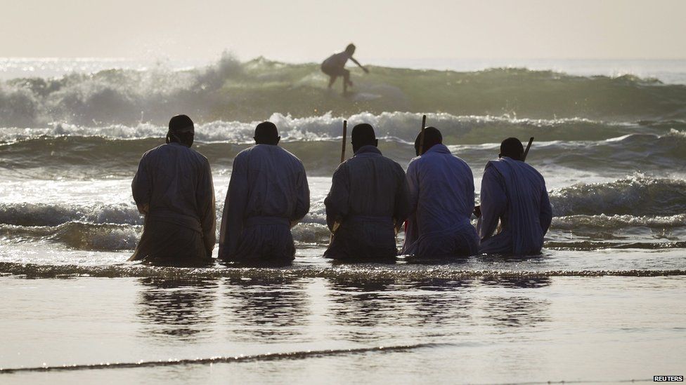 Members of South Africa’s Shembe Church kneeling in water on a beach in Durban, South Africa - Saturday 5 October 2013