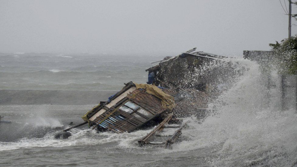 A house is engulfed by the storm surge brought about by powerful typhoon Haiyan that hit Legazpi city