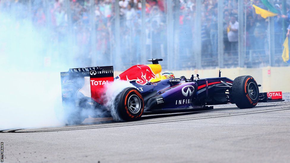 Sebastian Vettel performs donuts in his car after winning the Brazilian GP