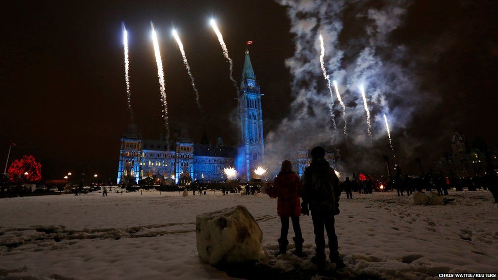 Children watch fireworks during a Christmas light illumination ceremony on Parliament Hill in Ottawa