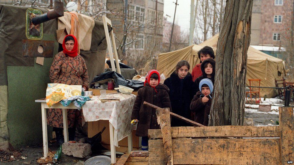 Survivors stand in an improvised camp for homeless in the devastated town of Leninakan, on December 15, 1988, after an earthquake hit Armenia, on December 7, 1988.