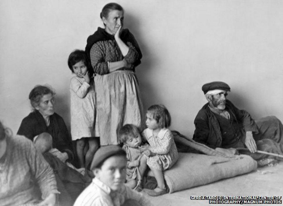 refugees looking distress, the center is an old woman, surrounded by kids