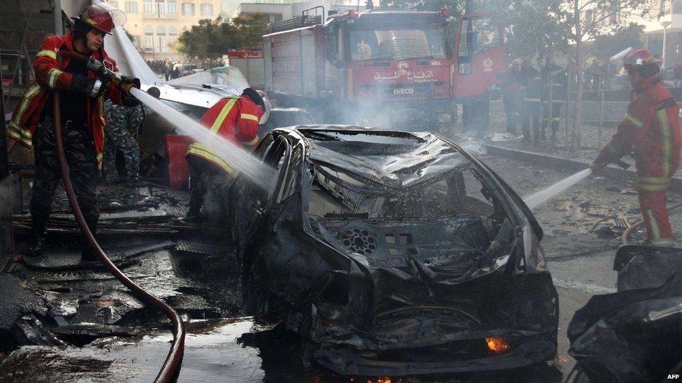 Firemen douse a burning vehicle following a car bomb explosion that rocked central Beirut (December 27, 2013)