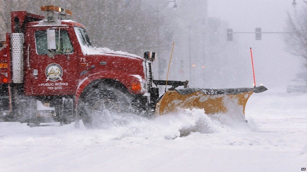 A city snow plough clears a street in an almost deserted Springfield, Illinois, as strong winds and snow move through the Midwest