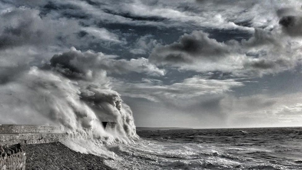 A towering wave hits Porthcawl's lighthouse