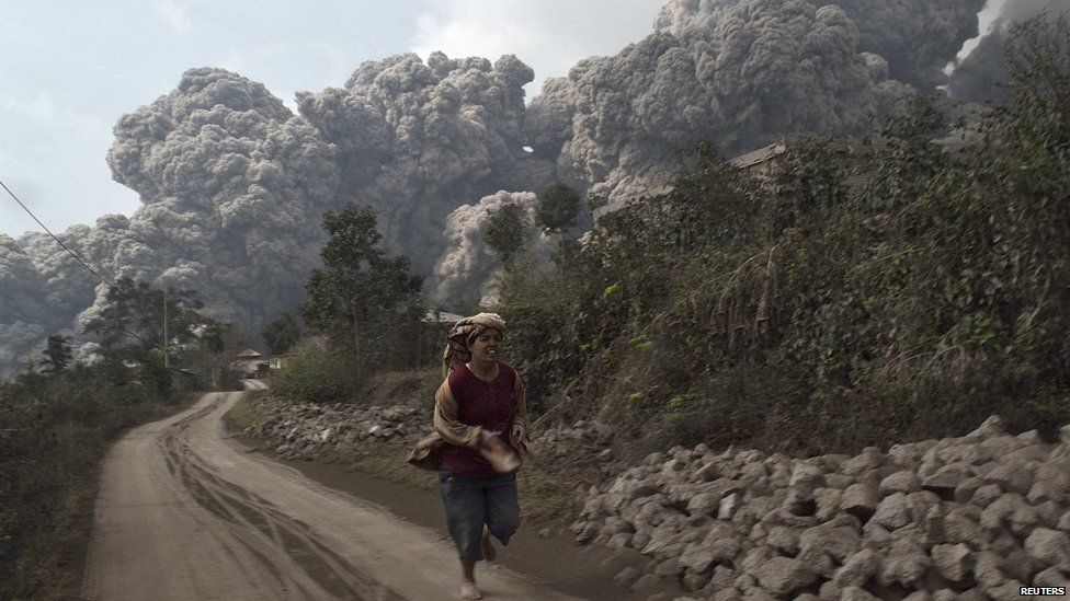 A villager runs as Mount Sinabung erupt at Sigarang-Garang village in Karo district, Indonesia's North Sumatra province, February 1