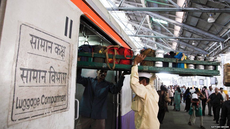 Dabbawala loading tray onto a train car