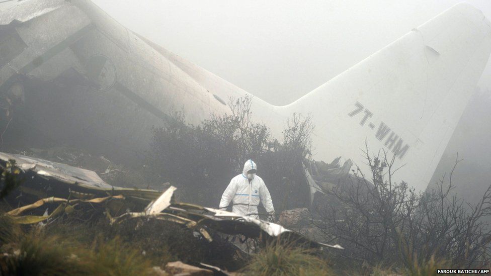 Algerian forensic inspect the wreckage of a C-130 Hercules