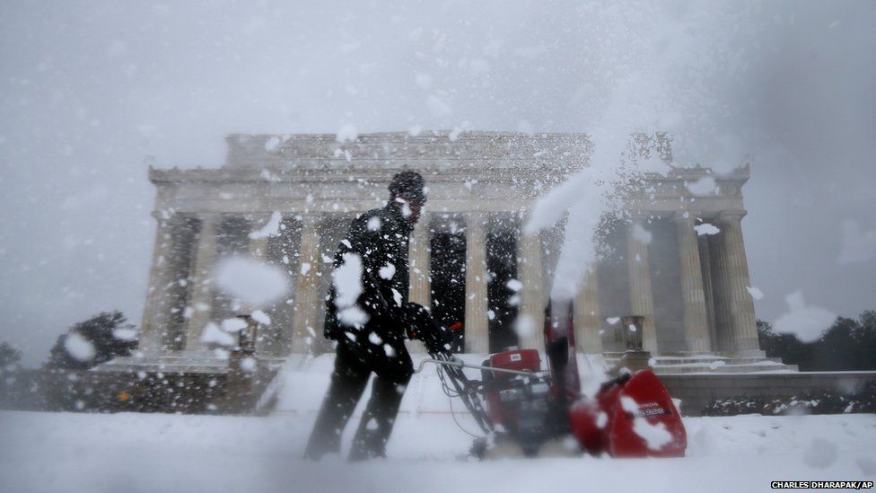A Park Service employee clears snow in front of the Lincoln Memorial in Washington