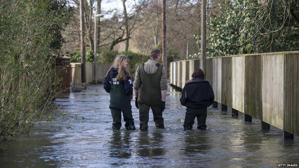 Residents walk along a flooded street in Henley-on-Thames