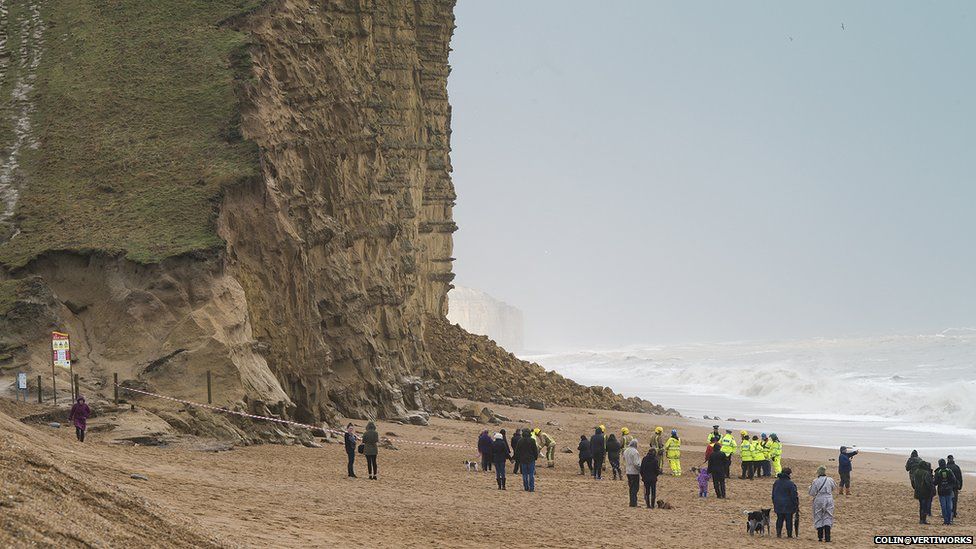 Emergency services and on-lookers after a cliff collapsed at West Bay, in Dorset