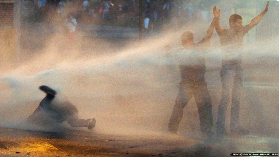 Supporters of opposition leader Leopoldo Lopez are hit by police's water canon during a protest against Nicolas Maduro's government in Caracas