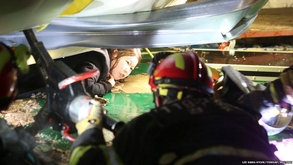 Firefighters try to rescue a university student trapped by debris from the collapsed resort in Gyeongju