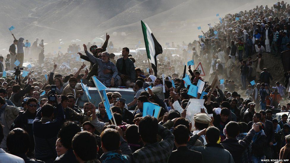 Afghan presidential candidate Abdulla Abdulla waves to a crowd of supporters as he arrives for political rally in Dashtak, Afghanistan