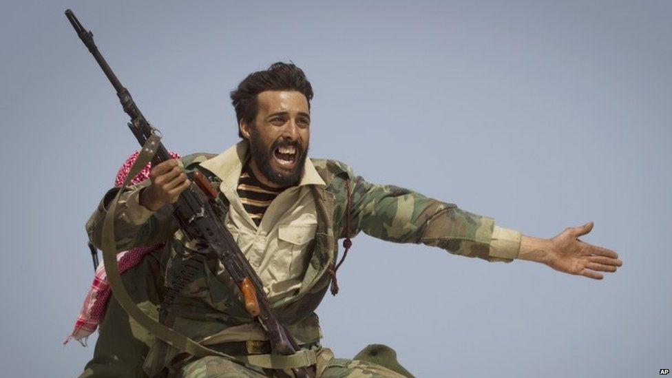A Libyan rebel fighter urges people to leave as Col Muammar Gaddafi's forces start shelling the frontline near the town of Bin Jawaad. Photo: 2011