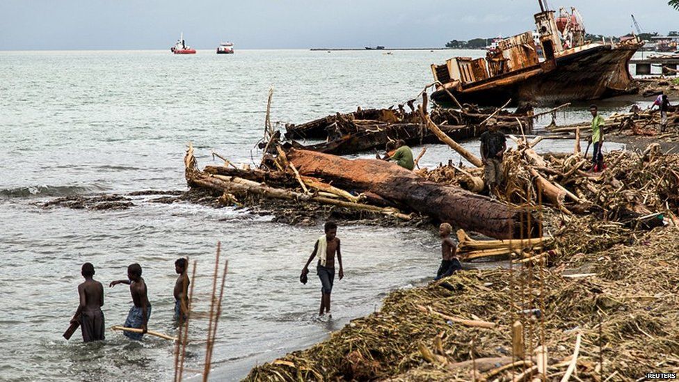 Locals walk amongst debris that was washed ashore as a result of severe flooding near the capital Honiara in the Solomon Islands in this picture released by World Vision on 6 April, 2014