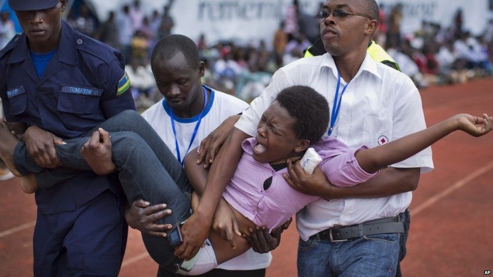 A wailing and distraught Rwandan woman is carried away to receive help during a public ceremony to mark the 20th anniversary of the Rwandan genocide in Kigali on 7 April 2014